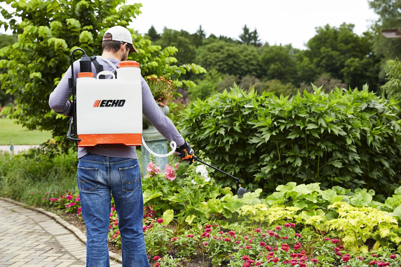 Man using Echo sprayer on flowers